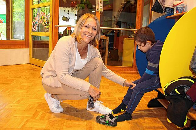 Katja Gethke, Gruppenleiterin im Kindergarten, zieht Samuel die Schuhe an. Die gelernte Erzieherin ist eine von zahlreichen ...