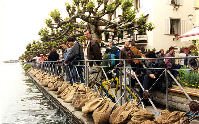 In Meersburg beobachten die Menschen den ansteigenden Bodensee. Mit Sandsäcken soll das Wasser von Straßen abgehalten werden.