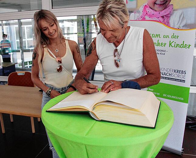 Matthias Reim trägt sich ins Goldene Buch der Nachsorgeklinik ein.