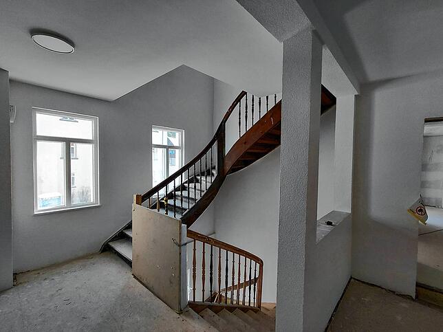 Blick in das erhaltene Treppenhaus. Jeder der drei Gebäudeflügel verfügt zusätzlich über einen Aufzug.