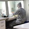 Der Molekularbiologe Dr. Lars Steinmüller-Magin öffnet eine Probe und behandelt die Viren vor, indem er die Virus-Hüllen unschädlich macht.