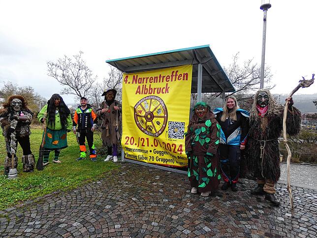 Vertreter der Albbrucker Narrenvereinigung vor einem Plakat, das zum 4. Narrentreffen am Wochenende in Albbruck einlädt.
