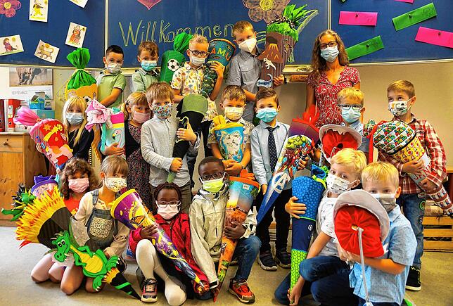 Erstklässler der Grundschule Wahlwies versammeln sich zusammen mit Klassenlehrerin Gela Adam im Klassenraum zum Gruppenbild.