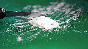 Kokainpulver und ein Messer liegen auf einer grünen Oberfläche. 90 Gramm des Rauschgifts fand die Polizei bei der Durchsuchung der ...