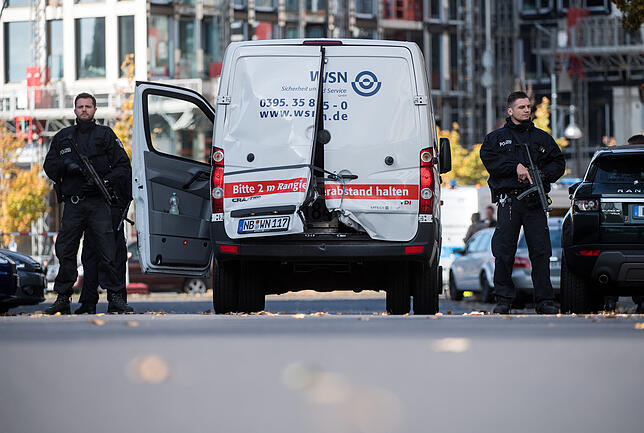 Polizisten mit Maschinenpistolen sichern einen Geldtransporter mit aufgebrochenen Türen in Berlin Mitte. Mehrere Maskierte hatten in der ...