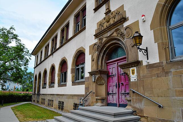 Eine große alte Holztür führt in das Gebäude des Amtsgerichts Stockach. Ganz hinten links sind die hohen Fenster des Gerichtssaals auf ...