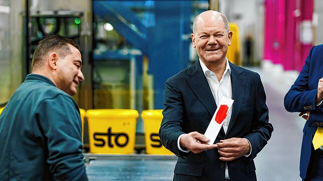 Bundeskanzler Olaf Scholz (SPD) hält beim Bauzulieferer Sto aus Stühlingen im Südschwarzwald einen Papierstreifen in klassischem SPD-rot ...