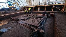 Mitarbeiter des Landesamtes für Denkmalpflege arbeiten bei Riedlingen an der komplett erhaltenen Grabkammer aus Holz.