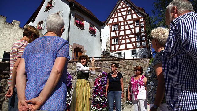 Eine Gästeführerein erläutert Touristen die Geschichte des Kelnhofplatzes. Bräunlingen hat viele kulturelle und historische Anker für ...