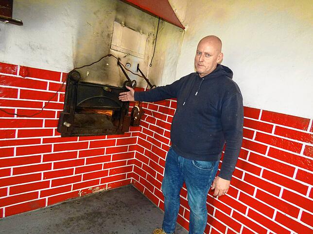 Jochen Rädeker zeigt den alten Holzofen. Hier soll wieder Brot gebacken werden.