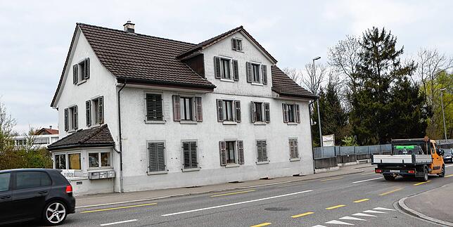 Vor dem Haus herrscht viel Verkehr. Rechts ist die Lärmschutzwand zu erkennen, die einen Teil des Grundstücks von der Straße abschottet.