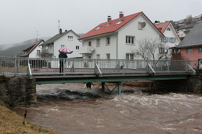 Eine Spaziergängerin in Vöhrenbach bestaunt das Hochwasser.
