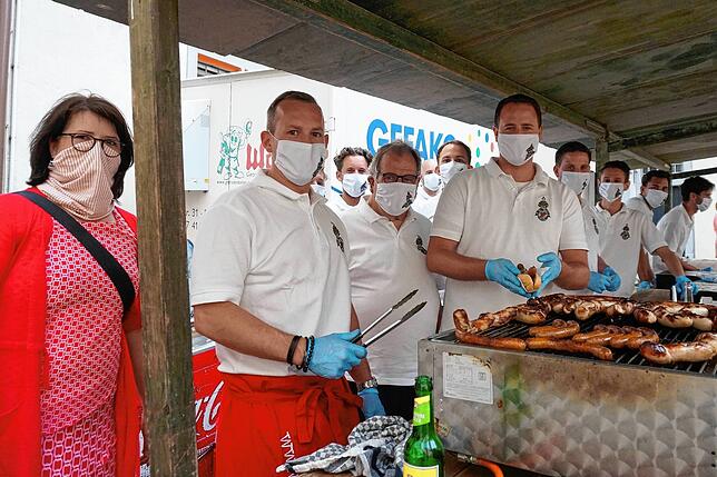 Mit Maske und Handschuhen: Surianer und Mitglieder der Aktionsgemeinschaft Tiengen (AG) hinter dem Grill- und Getränkestand auf dem ...