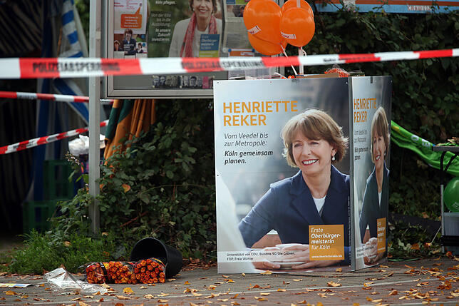 Plakate der damaligen Kölner Obermeisterkandidatin Henriette Reker stehen hinter Absperrbändern der Polizei am Tatort. Die Kölner ...