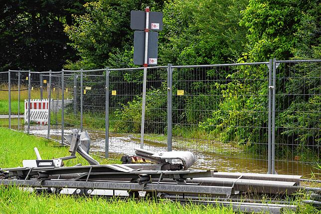 Der Fußweg zwischen Freibad und Eisweiher hinter dem Bauzaun ist überschwemmt.