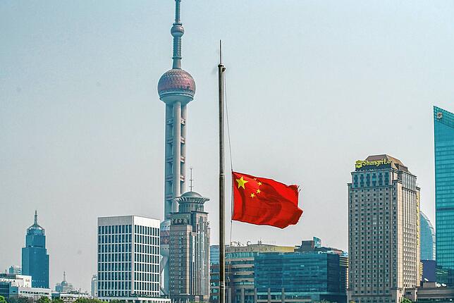 Die Skyline von Shanghai und eine Flagge auf Halbmast: Am Samstag, 4. April, gedachte China den bisherigen Todesopfern der ...