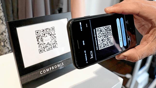 So läuft die Nutzung der Luca App. Ein Mann checkt sich bei einem gewerblichen Anbieter ein, indem er den QR-Code des Geschäfts mit ...