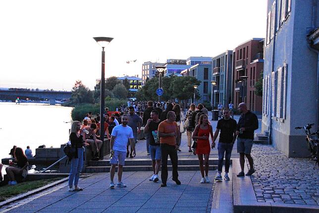 Die Menschen schlendern am frühen Abend friedlich am Seerhein entlang.