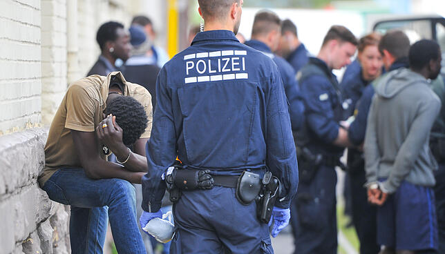 Polizisten überwachen während einer Drogenrazzia in der Landeserstaufnahmestelle Mannheim Verdächtige. Unter Geflüchteten, die mit ...