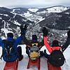 Diese drei Rodler freuen sich über die grandiose Aussicht auf die verschneite Landschaft an der Hasenhorn-Winterrodelbahn in Todtnau.
