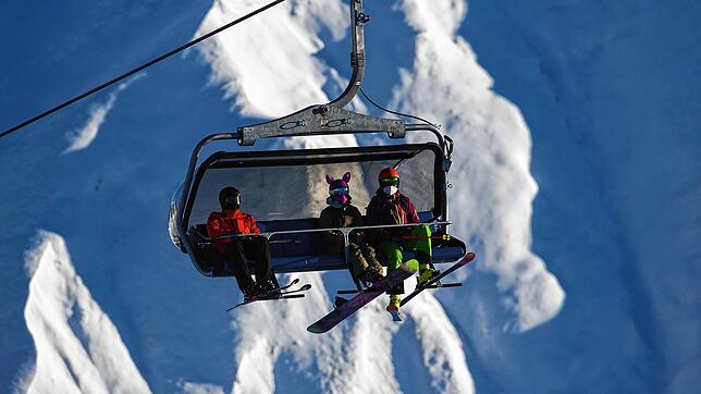 Skifahrer tragen FFP2-Schutzmasken in einem Sessellift im Skigebiet Silvretta Arena in Samnaun. Der Skiurlaub ist auch nach der ...