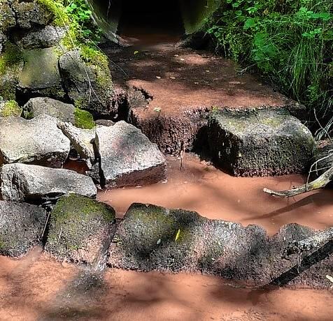 Aus dem Zulauf fließt rotbraune Sedimentbrühe in den Warenbach.