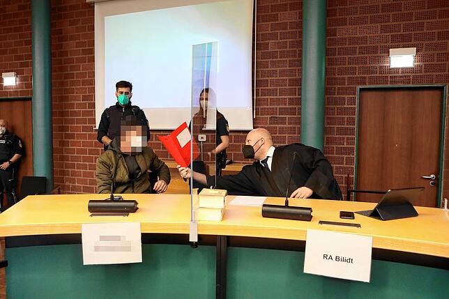 Verteidiger Björn Bilidt zeigt seinem Mandanten Adrian P. kurz vor Prozessbeginn noch Unterlagen.