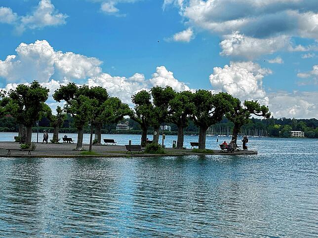 Besucher flanieren am Montagmittag durch den Stadtgarten und genießen den Blick auf den See.