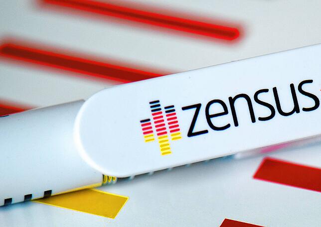 ARCHIV – 31.05.2013, Sachsen, Dresden: Der Schriftzug “Zensus„ ist auf einem bedruckten Kugelschreiber und einem Notizblock zu lesen. ...