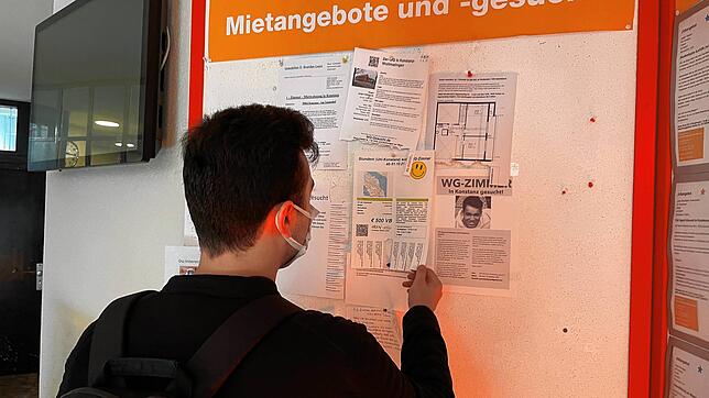 Ein Student schaut sich in der Universität Konstanz die Wohnungsanzeigen an. Doch dort gibt es fast nur Wohnungsgesuche.
