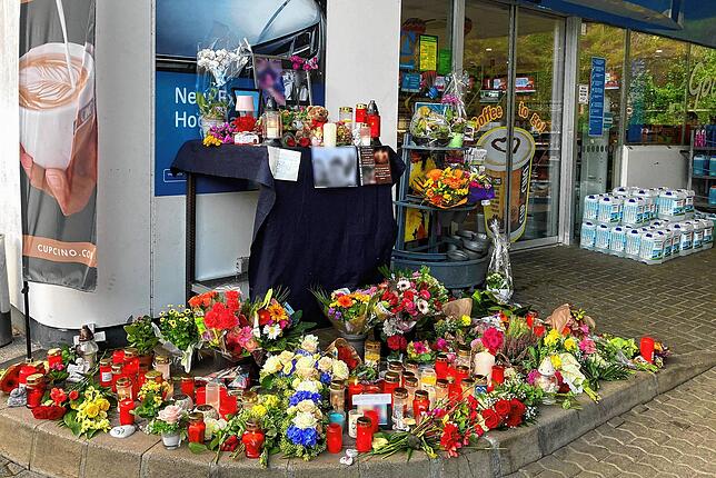 Blumen und Kerzen sind vor der Tankstelle aufgestellt, an der der junge Mann am 18. September getötet wurde.
