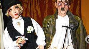 Diese beiden Figuren kommen einem irgendwie bekannt vor: Marlene Dietrich mit einem verlumpten Adolf Hitler.