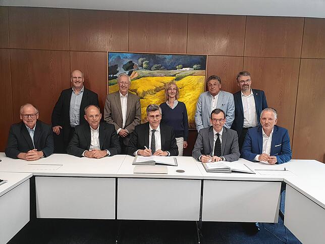 Landrat Martin Kistler (Mitte) und Christian Schneider (zweiter von rechts) von der Vamed-Geschäftsleitung unterzeichnen 2023 den ...