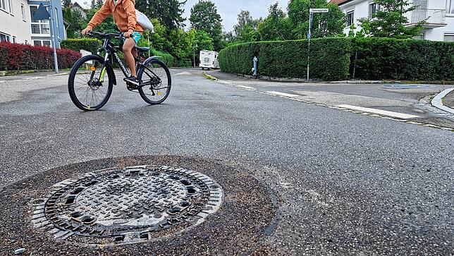 So sieht die Stelle am nächsten Morgen aus: Frischer Asphalt rund um einen sanierten oder getauschten Schachtdeckel.