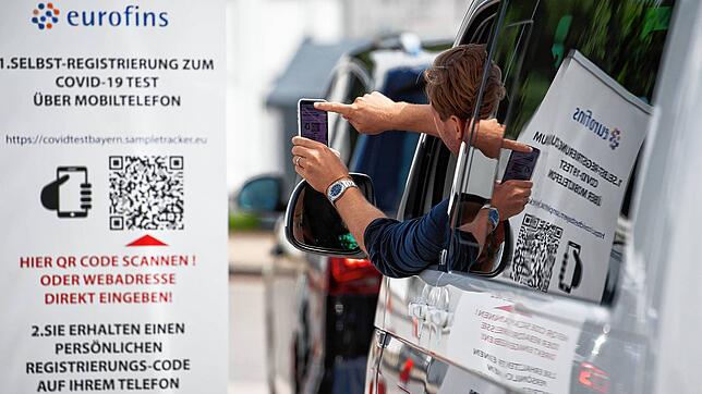 Ein Mann scannt an einem Corona-Testzentrum an der Autobahn 93 einen QR-Code, mit dessen Hilfe man sich für den Test anmelden kann. Das ...