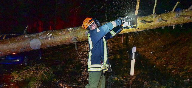 Manuel Bürkle im Einsatz. In der Sturmnacht muss er einen auf die Straße gestürzten Baum absägen, um einen Autofahrer zu befreien.
