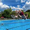Ein junger Mann springt mit einem Salto ins Schwimmerbecken des Waldshuter Freibads.