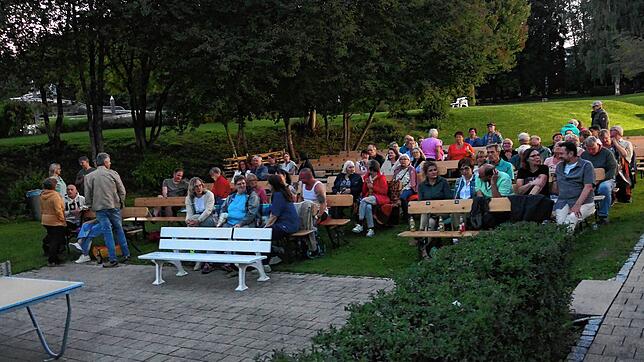 Einige Gäste machen es sich beim Open-Air-Kino auf den Bänken gemütlich. Johannes Menton (links) und Günther Sperlich sorgen als Team ...