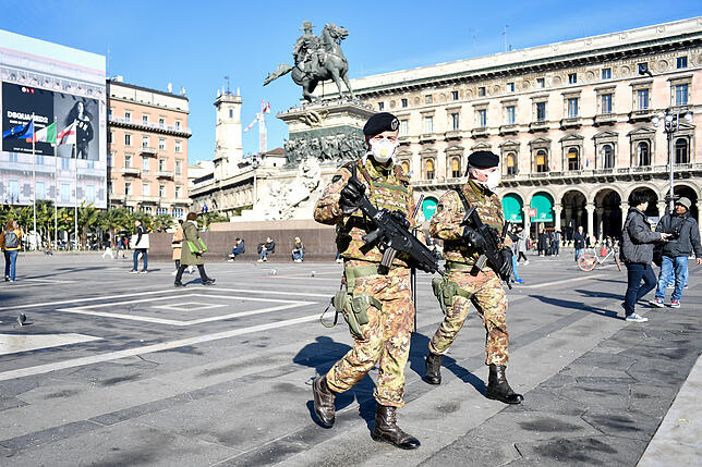 Soldaten tragen Mundschutz und patrouillieren über den Domplatz in Mailand.