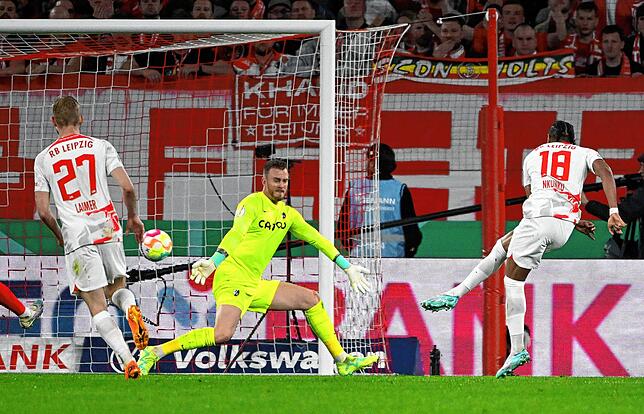 Leipzigs Christopher Nkunku (r) erzielt gegen Freiburgs Torwart Mark Flekken das Tor zum 4:0.