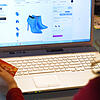 Eine junge Frau beim Online-Shopping mit Laptop und Kreditkarte.