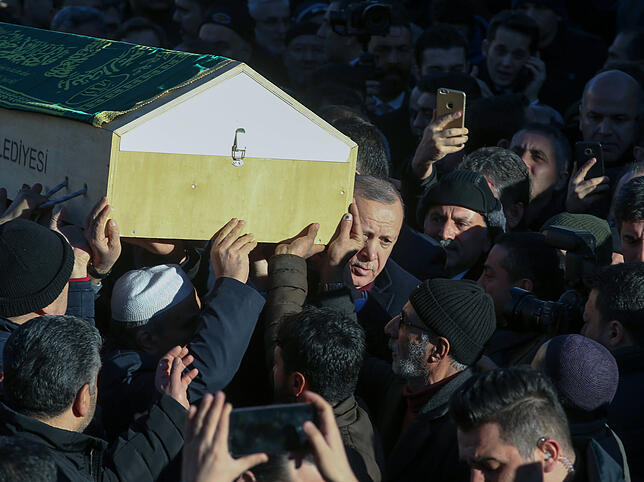 Präsident Recep Tayyip Erdogan trägt den Sarg eines der Erdbebenopfer mit.