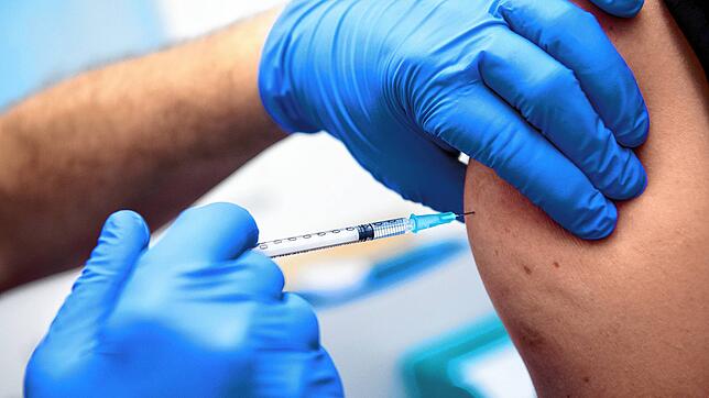 Ein Mitarbeiter der Asklepios Klinik wird von einem Kollegen mit dem Corona-Impfstoff von Biontech/Pfizer geimpft.