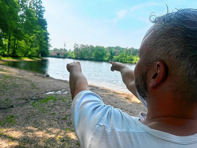 Der 41-Jährige zeigt auf den Damm, der laut Gutachten droht, brechen zu können.