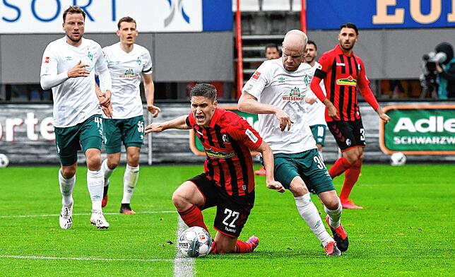Roland Sallai von Freiburg und Davy Klaassen von Bremen kämpfen um den Ball.