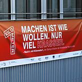 Mit einem Banner wirbt Kilometer 1 an der HTWG für ihr Projekt. Darauf steht: „Machen ist wie wollen. Nur krasser.“