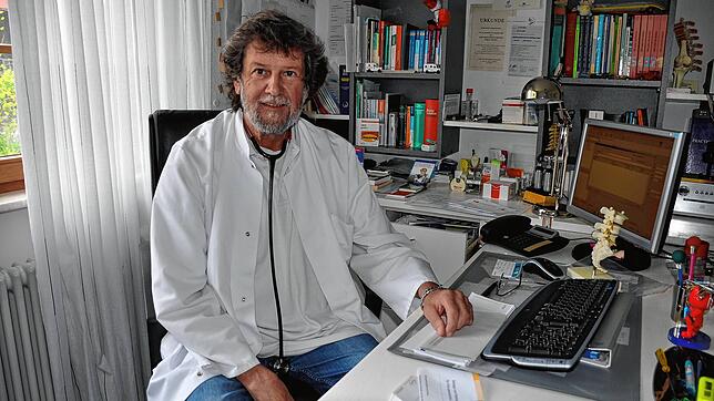 Der Arzt Alfred Müller an seinem Schreibtisch im Behandlungszimmer.