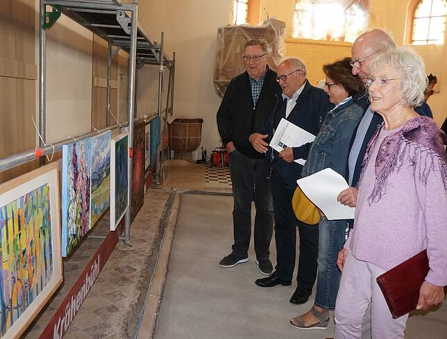 Kunst in der Baustelle Christuskirche: Vor der Versteigerung hängen die Bilder am Gerüst und werden von vielen interessierten Besuchern ...