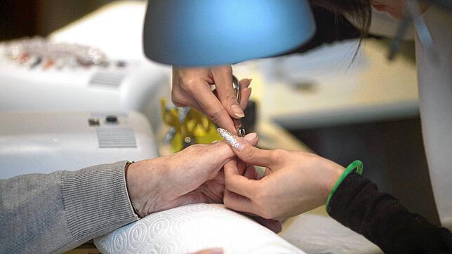 Extravagante Fingernägel trägt eine Helferin bei ihrer Arbeit in einem Nagelstudio (Symbolbild). Eine 44-jährige Nagelstudio-Betreiberin ...