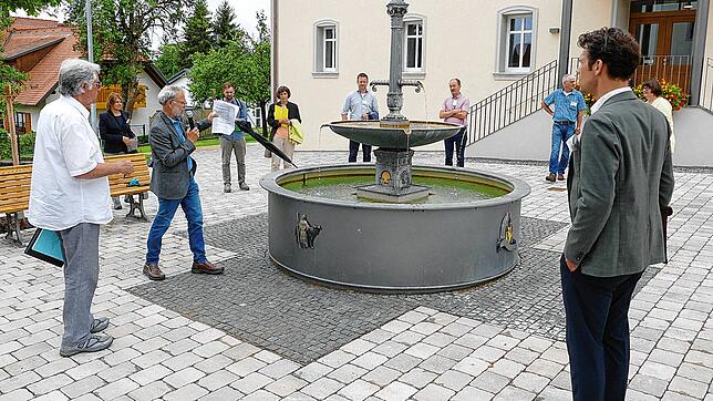 Thalheims Ortsvorsteher Hubert Stekeler präsentiert der Jury den neugestalteten Dorfplatz vor dem Haus der Vereine.